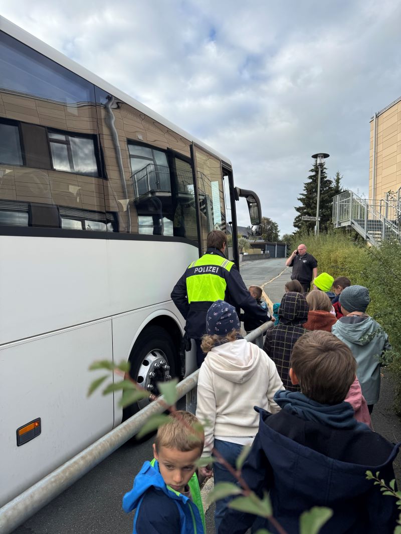 Kinder stehen vor dem Bus